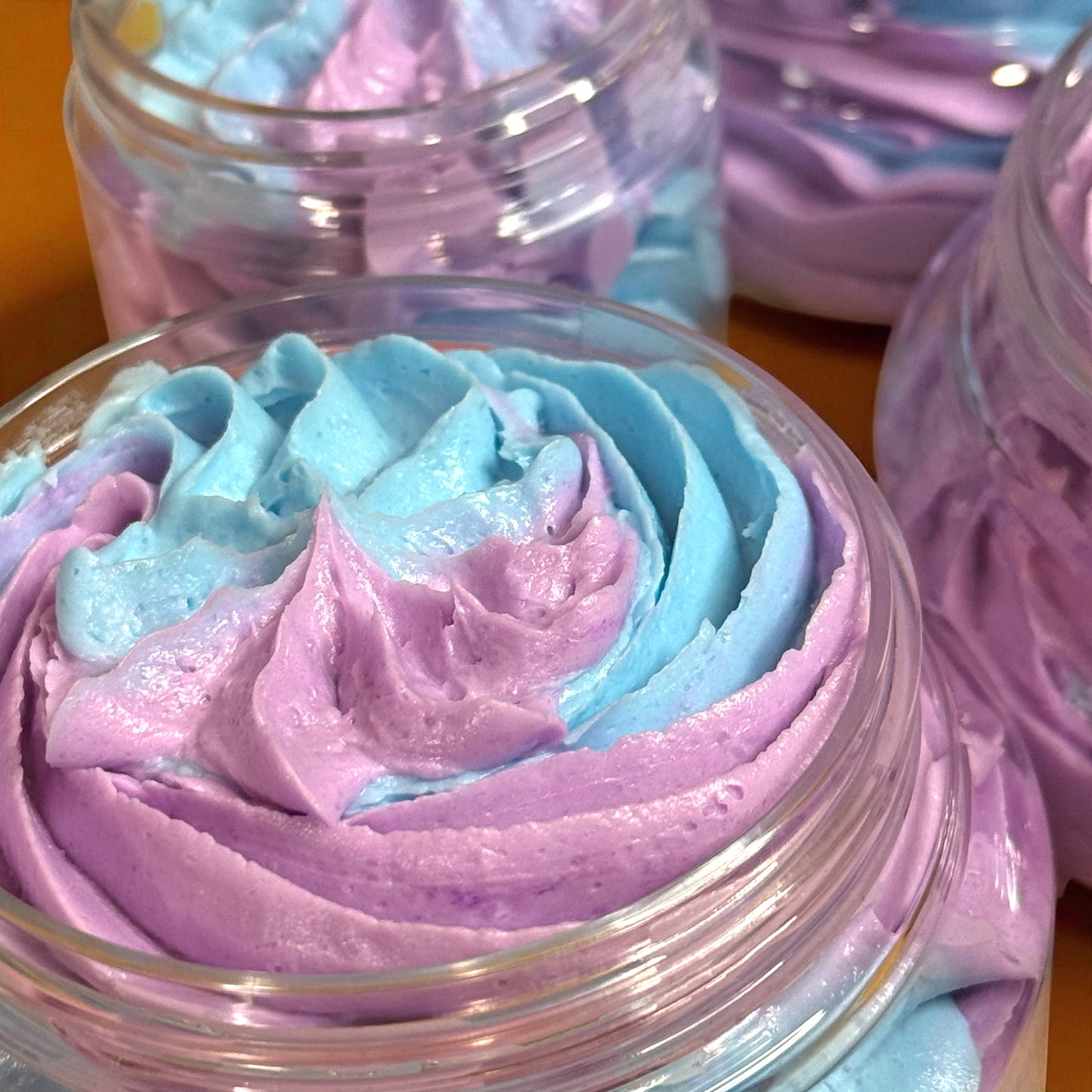 Close-up of a container with pink and blue whipped cream-like substance.