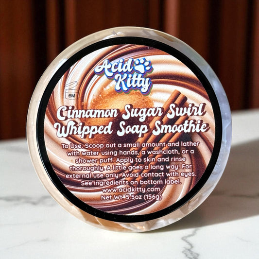 Cinnamon sugar swirl whipped soap smoothie container with 'Acid Kitty' branding on a marble surface.