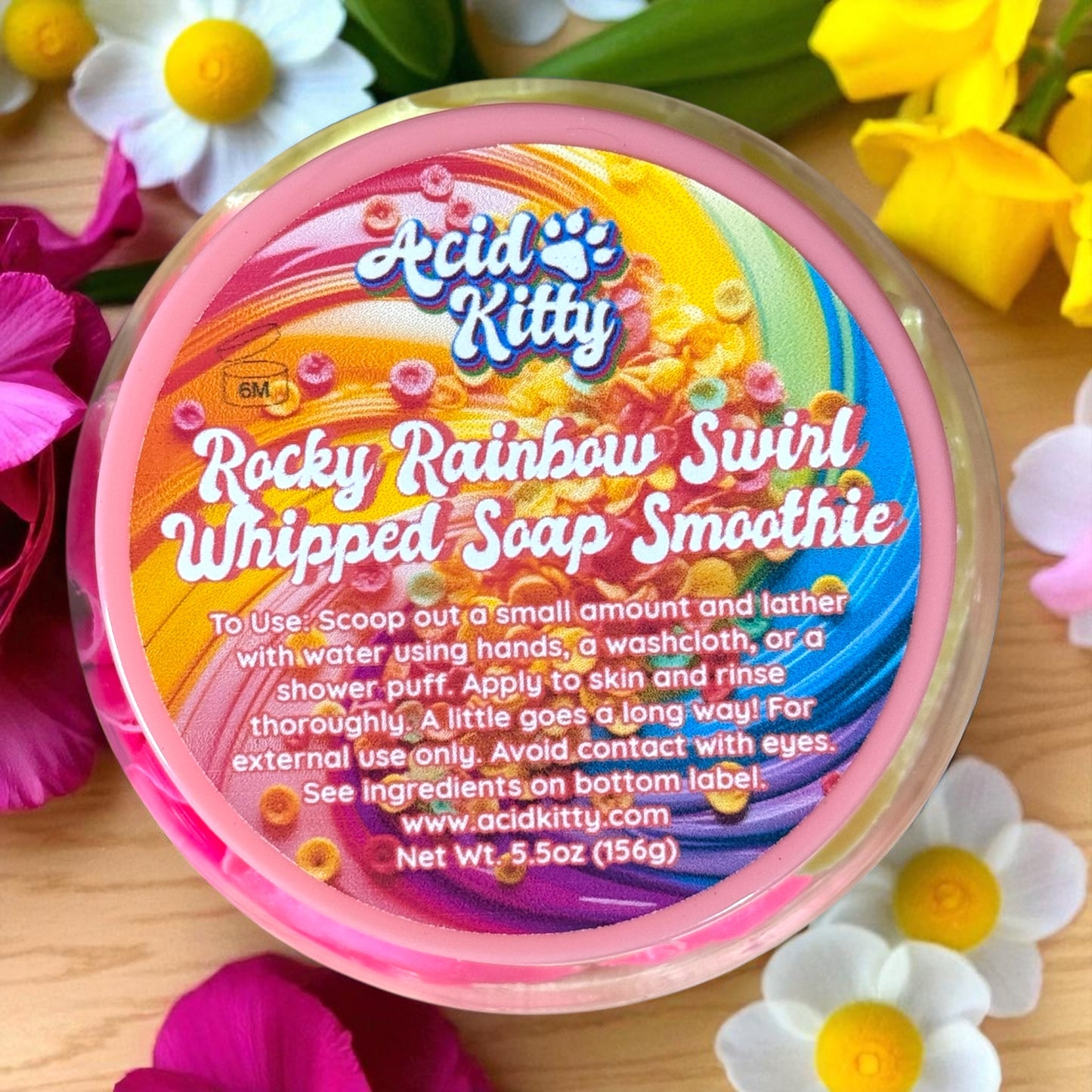 Container of Acid Kitty Rocky Rainbow Swirl Whipped Soap Smoothie with colorful label on a floral background