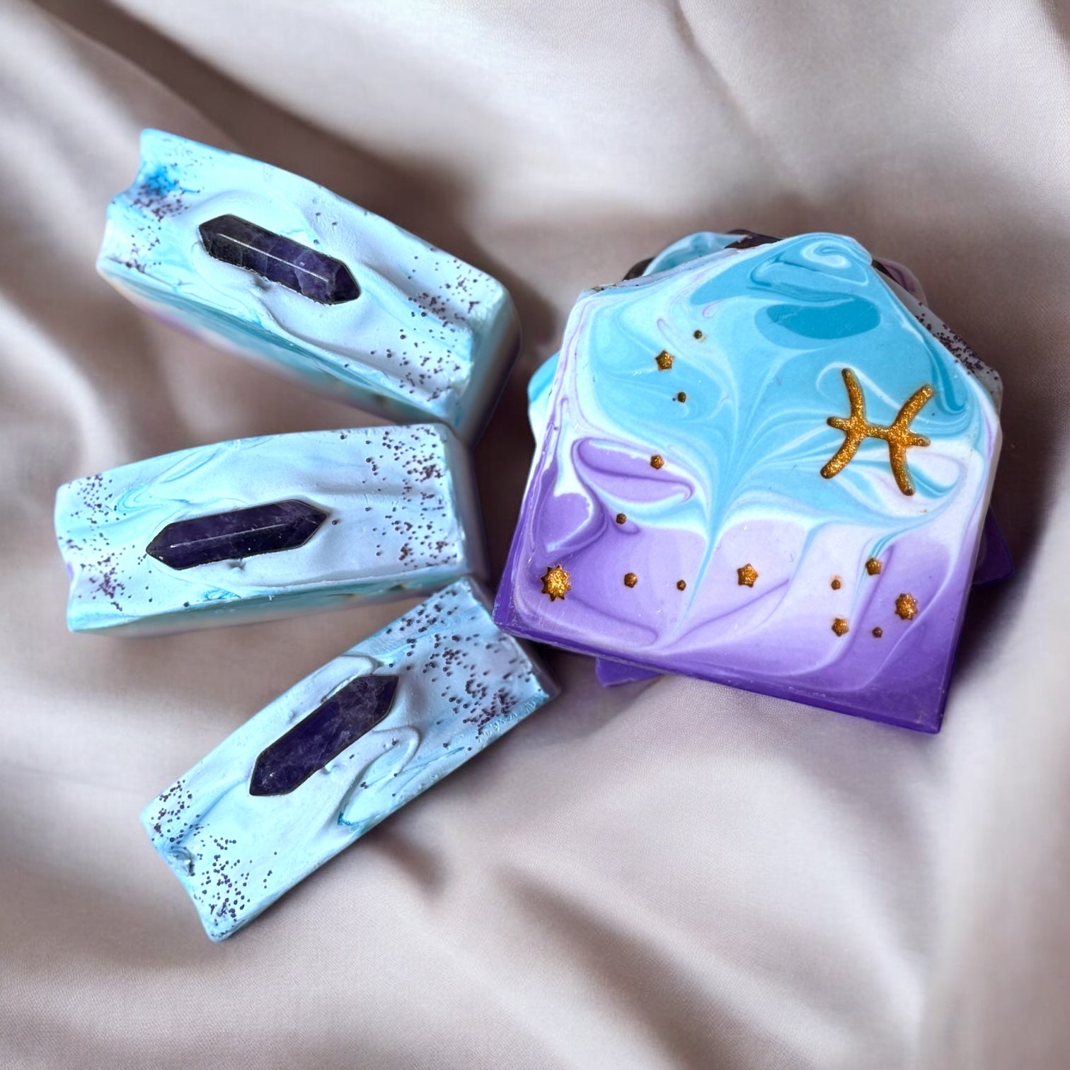 A bar of soap with purple and lavender swirls, featuring gold stars and the Pisces symbol.