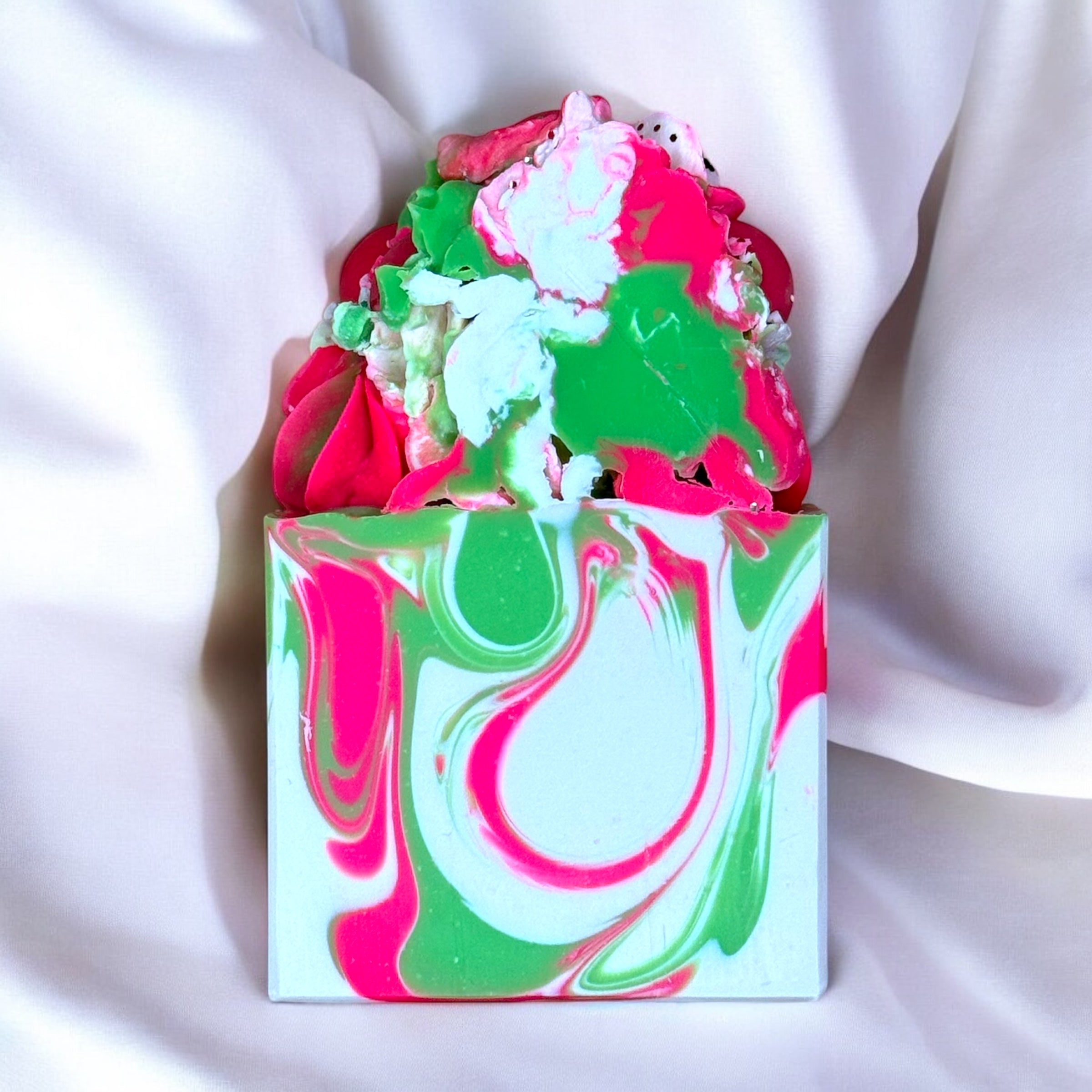 A bar of strawberry kiwi scented soap with a colorful design featuring predominantly pink and green hues.