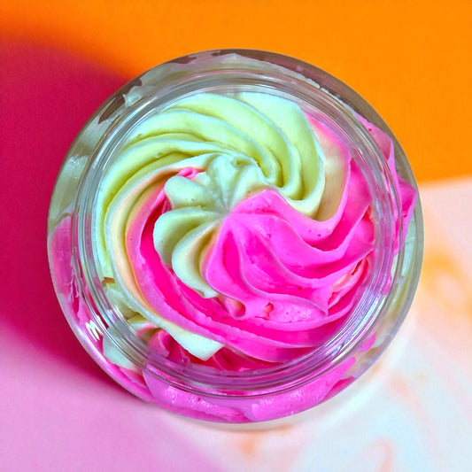 Colorful whipped creamy soap swirl in a glass container on a multicolored background