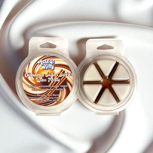 Cinnamon Sugar Swirl wax melts in warm cinnamon and cream-colored tones in a circular clamshell. 